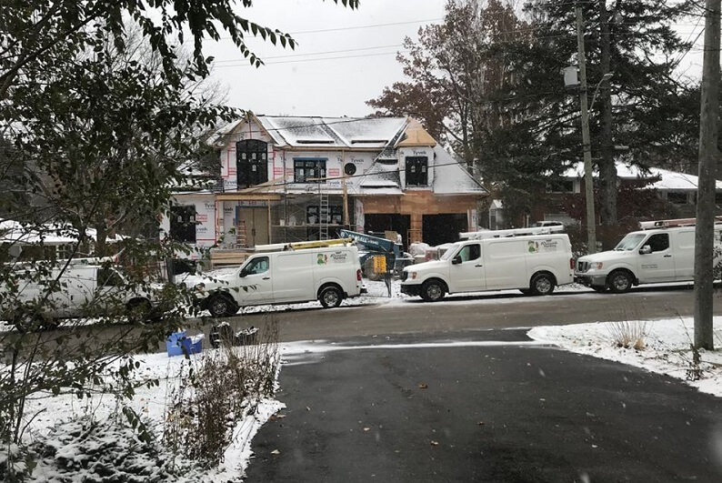 custom home being built with trucks in front